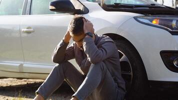 Sad driver sits near a broken car in the middle of the highway video