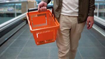 A man walking in aisle with shopping baskets at supermarket video