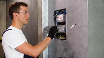 Professional electrician sets up electricity in the apartment video