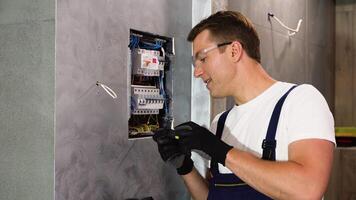 elettricista riparazione elettrico scatola e utilizzando Cacciavite nel corridoio. elettrico shock video
