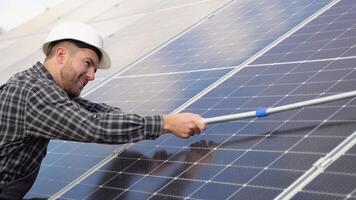 Masculin ingénieur nettoyage solaire panneaux avec brosse et l'eau video