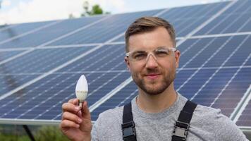 Engineer standing with lamp on solar panel and feeling freedom at view point. Alternative energy ecological concept video