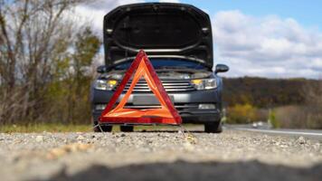 voiture avec des problèmes et un triangle rouge pour avertir les autres usagers de la route video