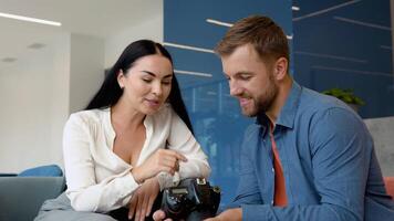 Photographer and model watch photos sitting in the business center video