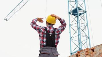 grave manager nel casco e uniforme dando comandi per gru operatore. barbuto uomo Esprimere a gesti e urlando durante Lavorando processi video