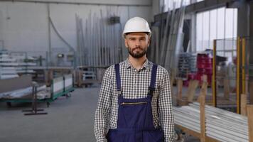 Fachmann schwer Industrie Ingenieur Arbeiter tragen Sicherheit Uniform Kommen zu das Kamera und lächelnd video