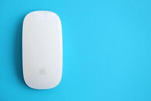 KYIV, UKRAINE - NOVEMBER 27, 2023 Apple Magic Mouse 3rd generation lies on bright colored background photo