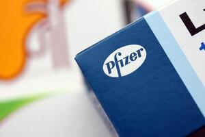 KYIV, UKRAINE - NOVEMBER 27, 2023 Pfizer logo on cardboard pill box in drug store photo