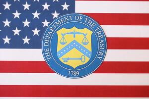 KYIV, UKRAINE - MARCH 9, 2024 US The Department of the Treasury seal on United States of America flag photo