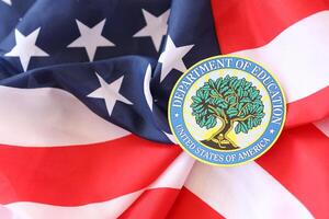 KYIV, UKRAINE - MARCH 9, 2024 US Department of Education seal on United States of America flag photo