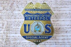 KYIV, UKRAINE - MARCH 9, 2024 US Interpol Special Agent badge on United States Constitution photo