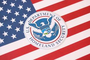 KYIV, UKRAINE - MARCH 9, 2024 US Department of Homeland Security seal on United States of America flag photo