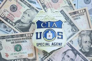 KYIV, UKRAINE - MARCH 9, 2024 US CIA Central Intelligence Agency badge on many US dollar bills photo