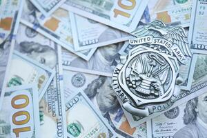 KYIV, UKRAINE - MARCH 9, 2024 US Army Military Police badge on many US hundred dollar bills photo