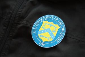 KYIV, UKRAINE - MARCH 9, 2024 US The Department of the Treasury seal on black jacket uniform photo