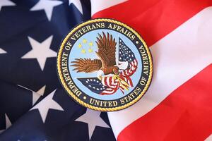 KYIV, UKRAINE - MARCH 9, 2024 US Department of Veteran Affairs seal on United States of America flag photo
