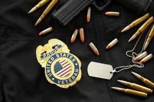 KYIV, UKRAINE - MARCH 9, 2024 US Proud Veteran badge on black jacket uniform with gun, bullets and dogtags photo