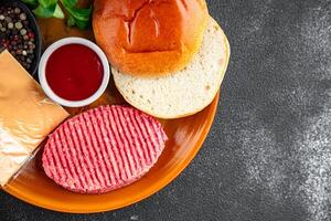 burger set raw cutlet, bun, cheese, tomato sauce, greens fresh cooking appetizer meal food snack on the table copy space food background rustic photo