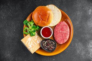 burger set raw cutlet, bun, cheese, tomato sauce, greens fresh cooking appetizer meal food snack on the table copy space food background rustic photo