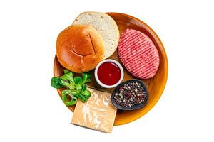 raw burger set cutlet, bun, cheese, tomato sauce, greens fresh cooking meal food snack on the table copy space food background photo