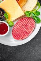 raw burger set cutlet, bun, cheese, tomato sauce, greens fresh cooking meal food snack on the table copy space food background photo