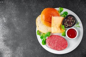 raw burger set cutlet, bun, cheese, tomato sauce, greens fresh cooking meal food snack on the table copy space food background photo