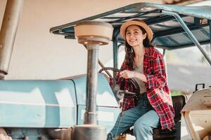 Joyful young farmer is seen operating a tractor, ready to start the workday on her sunny, productive farm. photo