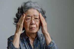 Asian elder woman suffering dizziness, vertigo, headache, fainting attack or stress. photo