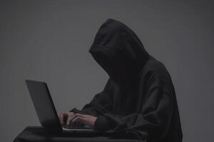 Anonymous hacker typing computer laptop. Cybercrime, cyberattack, dark web concept. photo