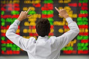 Back view of successful trader in front of stock market board photo