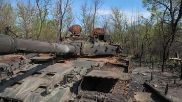 Destroyed and burnt-out tank of the Russian army as a result of the battle with Ukrainian troops in the forest near Kyiv, Ukraine. Russian aggression in Ukraine. video