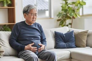 Asian senior man suffering from abdominal pain. photo