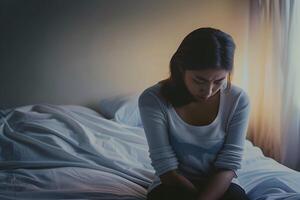 asiático niña sensación triste y solitario en el dormitorio debajo oscuro ligero foto
