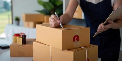 Woman in an online store check the customer address and package information on box. Online shopping concept photo