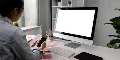 Woman sit at workplace desk with digital graphic staring at computer white mock up screen working professional program concept photo