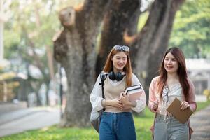 Universidad estudiante niña amigos con aprendizaje libro Universidad mientras caminando en instalaciones foto