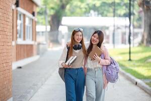 University student girl friends with learning book college while walking in campus photo