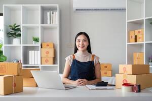 Woman asian in an online store check the customer address and package information on the laptop. Online shopping concept photo