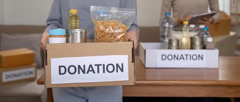 voluntario preparando gratis productos alimenticios raciones para pobre gente. caridad dos mujer de el comunidad trabajo juntos. concepto de dando y humanitario ayuda foto