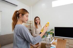 Donation and two woman volunteer asian of happy packing food in box at home. Charity photo