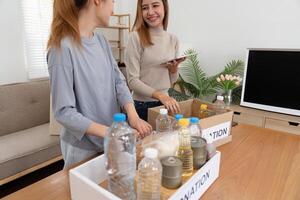 Woman with charity box and group of volunteers at assistance center. Charity, donation, and volunteering concept photo