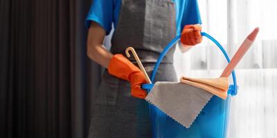 Cleaning product, and basket with woman staff cleaning service in bedroom to clean bacteria at apartment. cleaner or maid with container to work in room photo