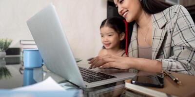 Working mom work from home office. businesswoman and cute child using laptop work freelancer workplace in home, Lifestyle family moment photo