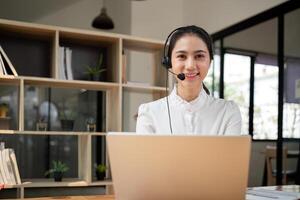 Call center friendly woman asian in office for customer service, technical support and advice, contact and communication with employee operator in help desk agency photo