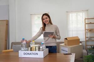 voluntario mujer asiático paquete donar comida en cartulina caja para personas en necesitar durante foto