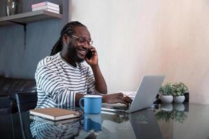 Professional man working remote from home with technology. African American male has a business meeting on an audio call phone photo