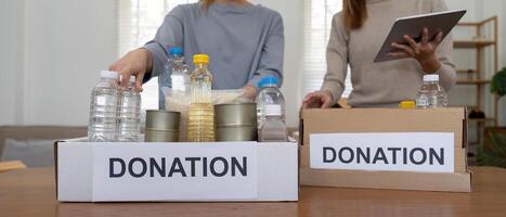 voluntario preparando gratis productos alimenticios raciones para pobre gente. caridad dos mujer de el comunidad trabajo juntos. concepto de dando y humanitario ayuda foto