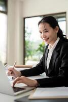 asiático mujer contabilidad sentar a su escritorios y calcular financiero grafico demostración resultados acerca de su inversión, planificación exitoso negocio crecimiento proceso foto