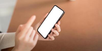 Mockup of a woman holding and using mobile phone with blank screen while laying down on the floor with feel relax photo