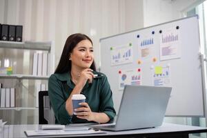 Business woman asian working about financial with business report and calculator on laptop in home office photo